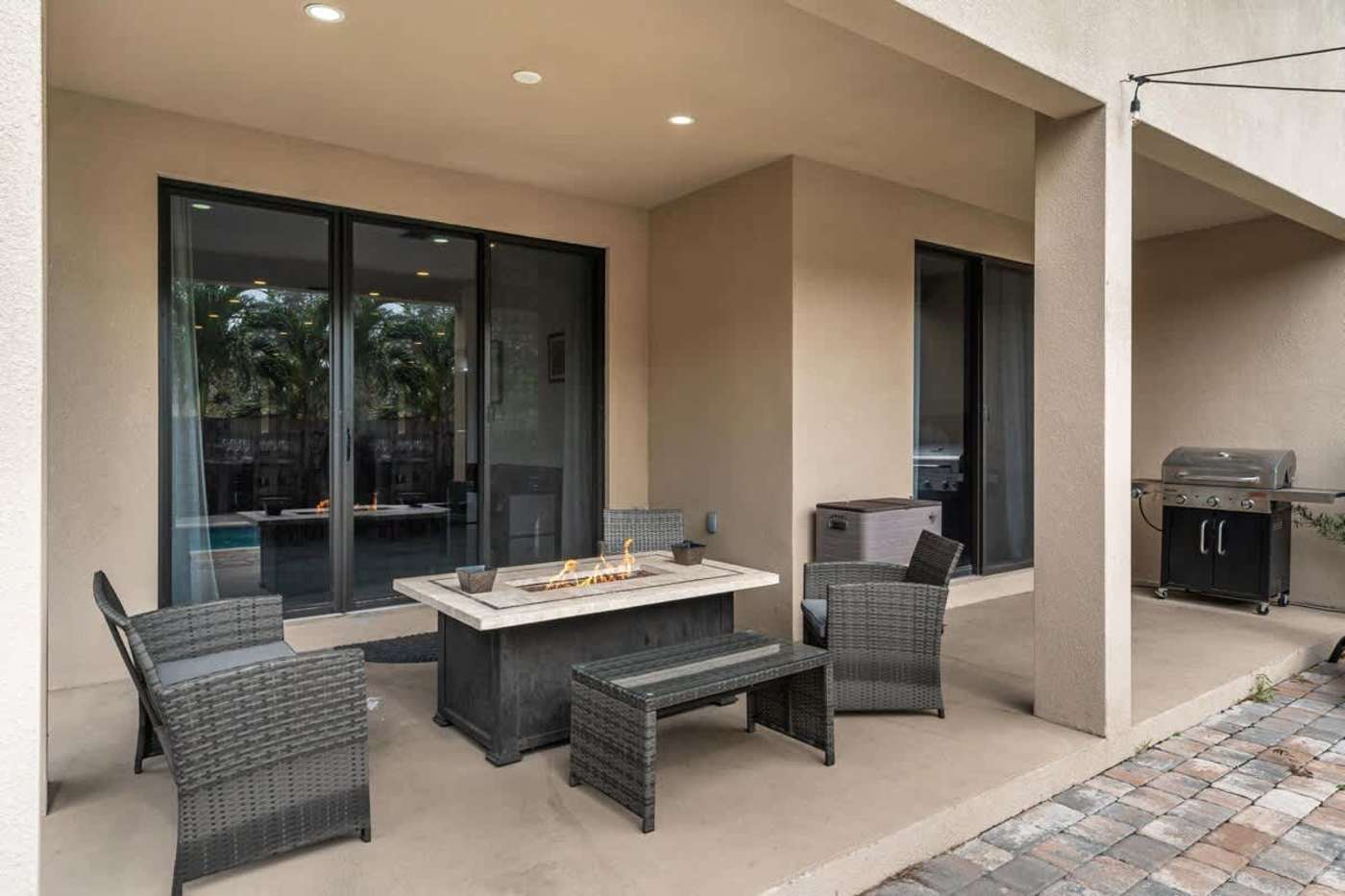 The Arcade House: Covered patio with fire pit table, lounge seating and a gas grill