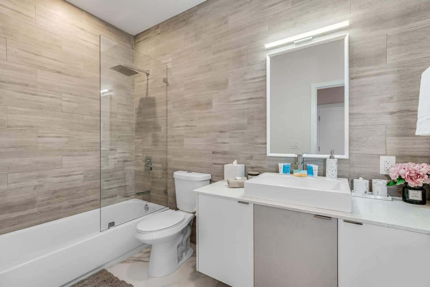 The Arcade House: Bathroom with bath, shower, vanity and a lit mirror