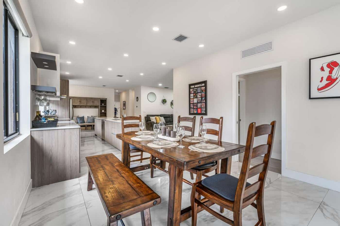The Arcade House: Dining table for six with a bench, beside the kitchen