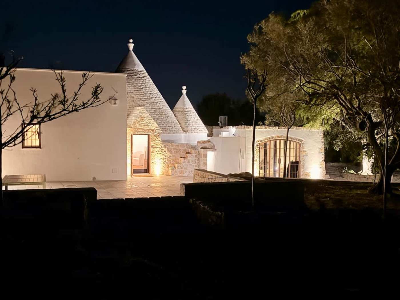 Trullo Ostro: Trullo and courtyard lit up at night