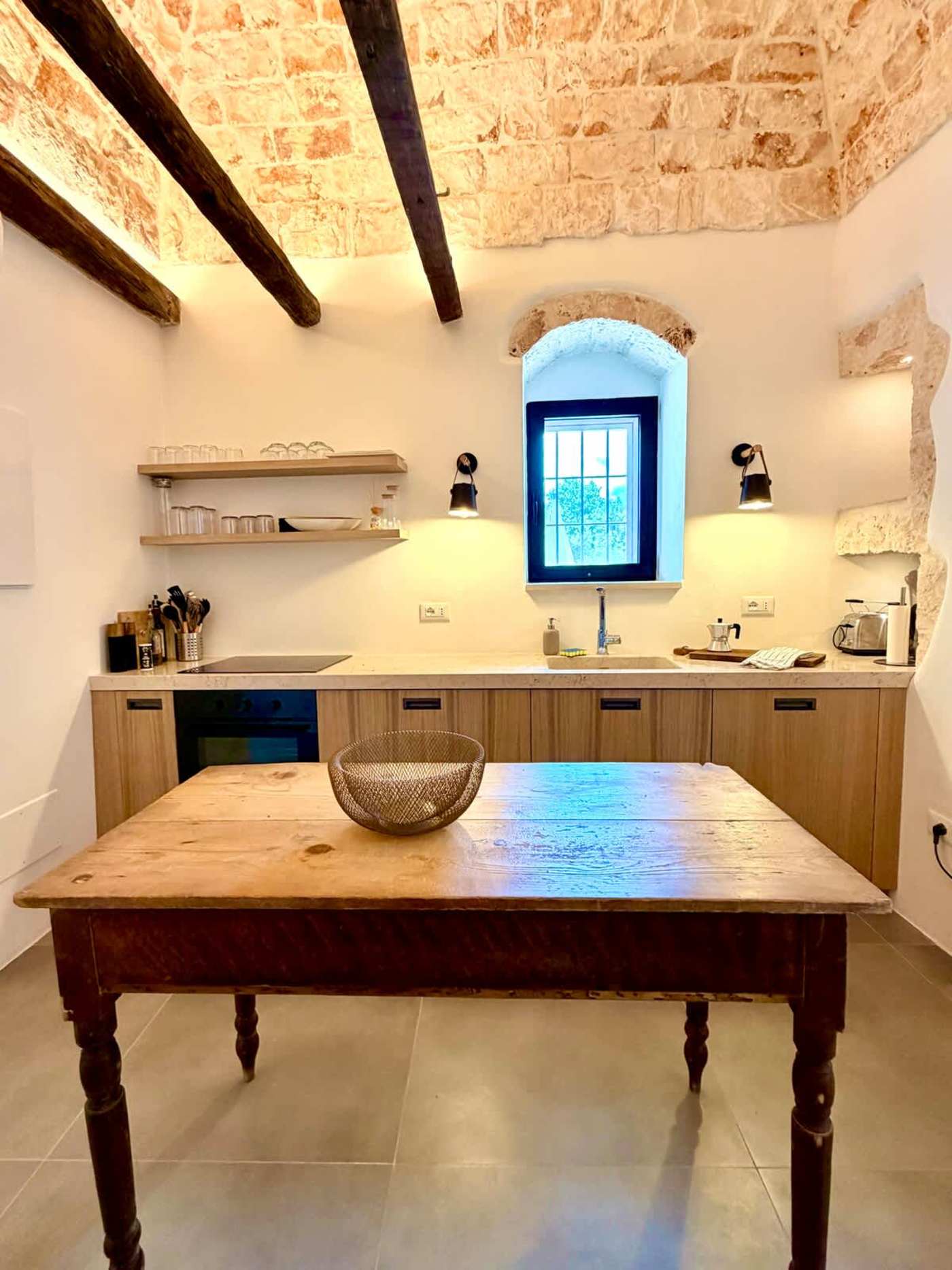 Trullo Ostro: Kitchen with open shelving, cooktop and farmhouse table