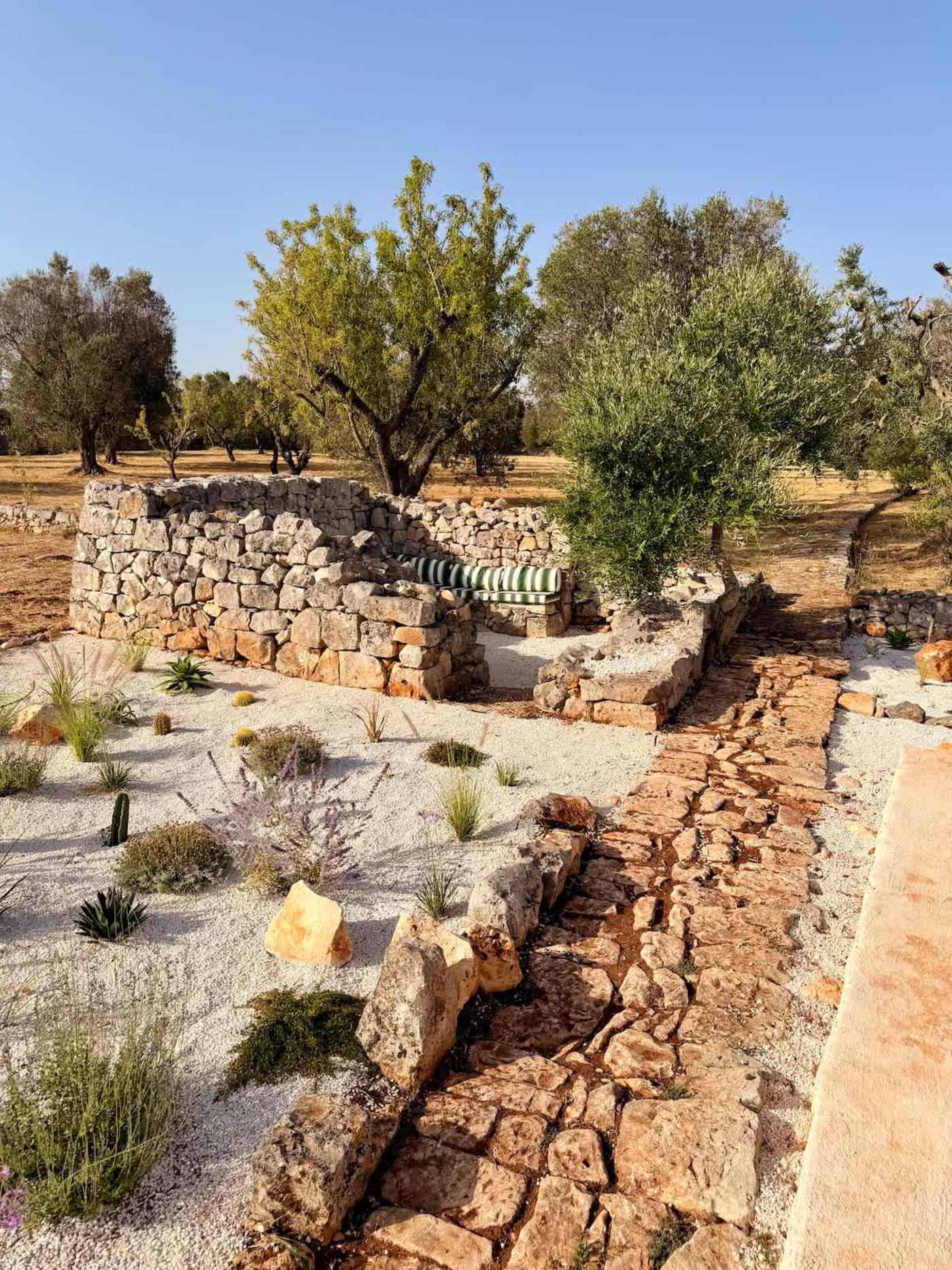Trullo Ostro: Gravel garden and stone path toward the fire pit lounge