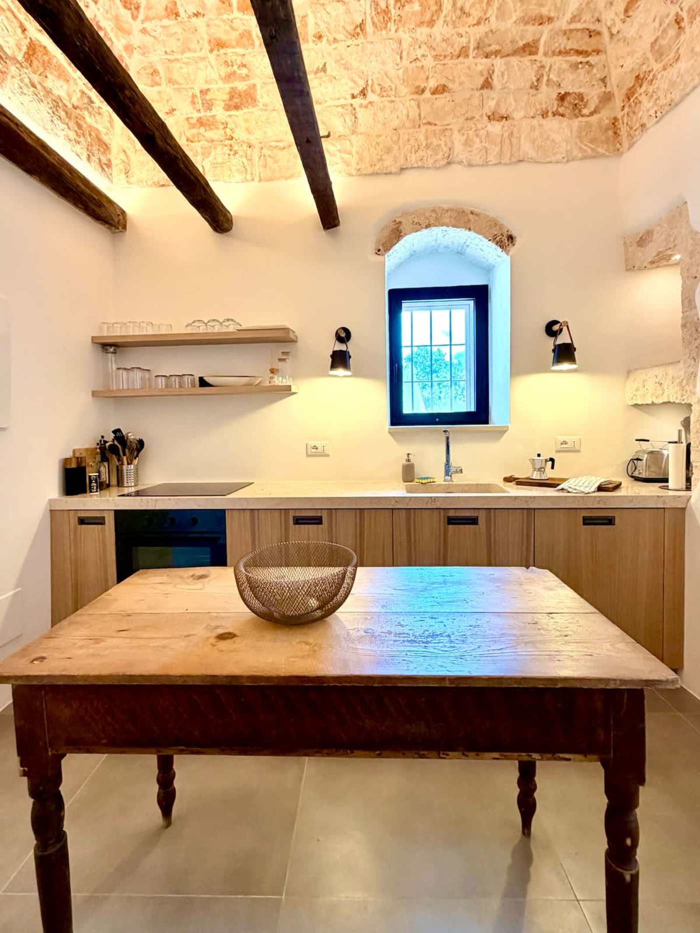Trullo Ostro: Kitchen with open shelving, cooktop and farmhouse table
