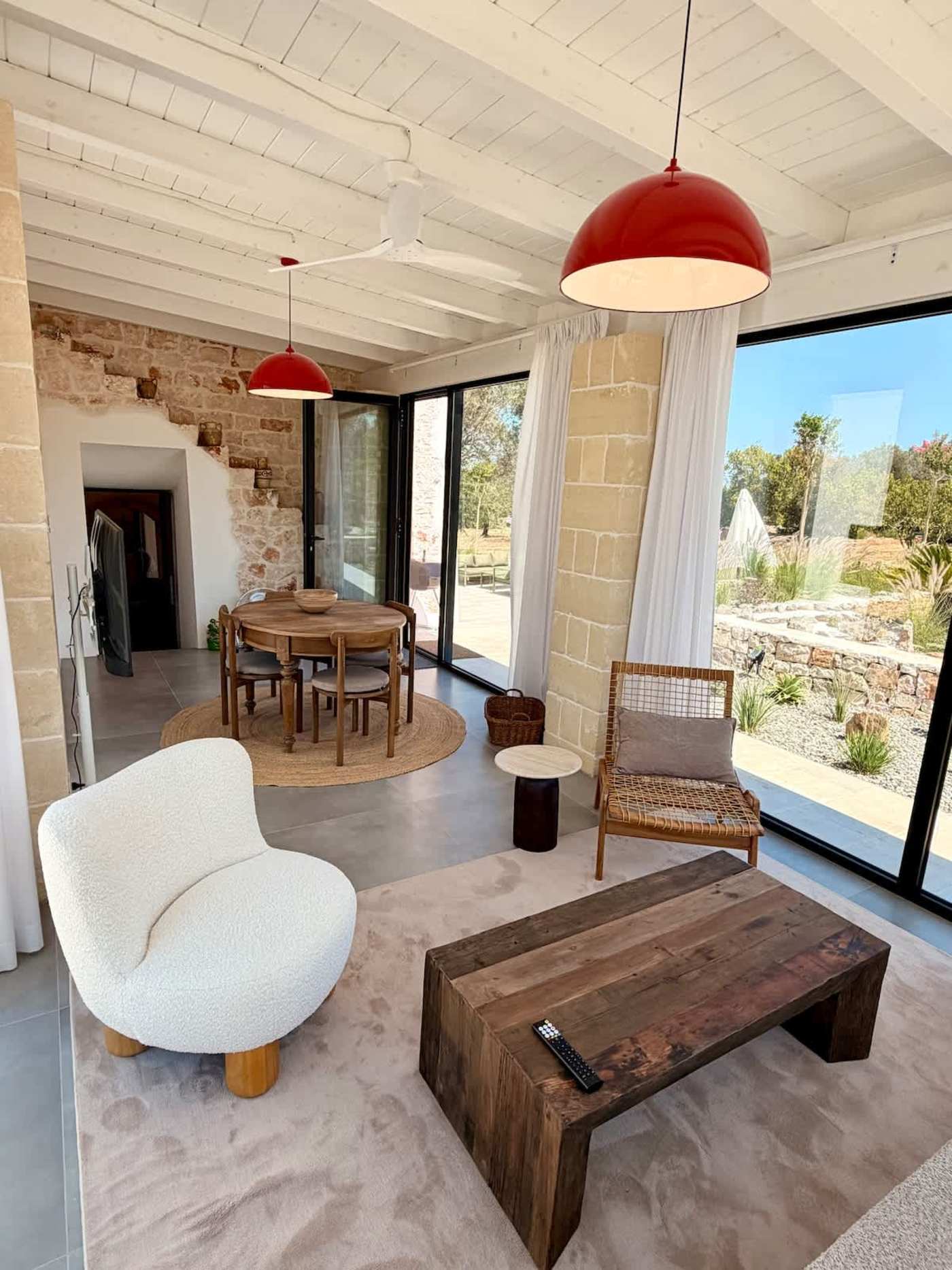 Trullo Ostro: Open-plan living and dining area with sliding glass walls