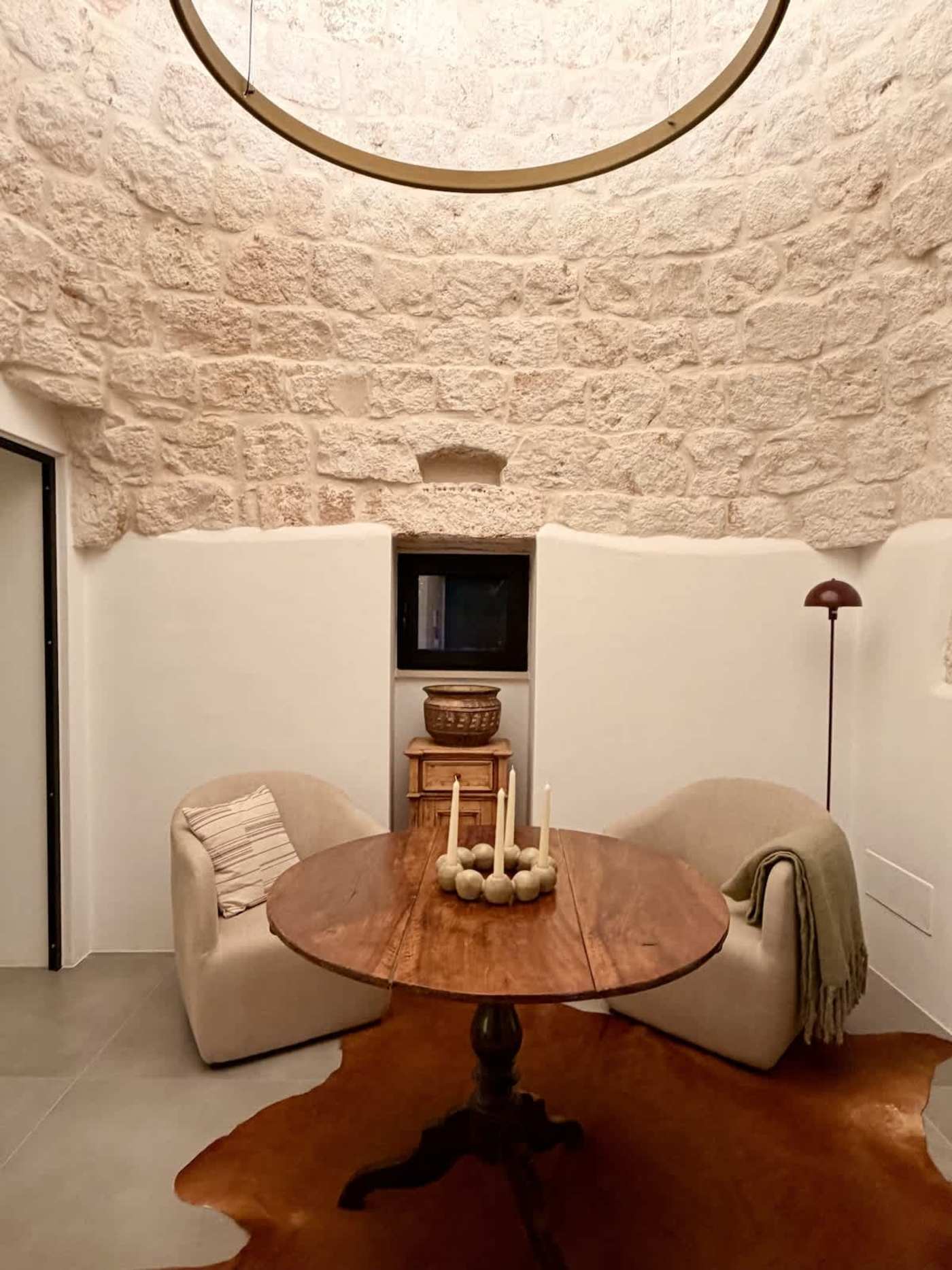 Trullo Ostro: Trullo sitting room with round table under the stone dome