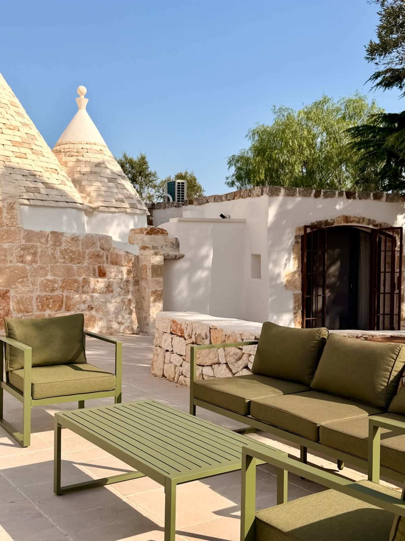 Trullo Ostro: Covered terrace lounge with sofa and armchairs beside the trullo