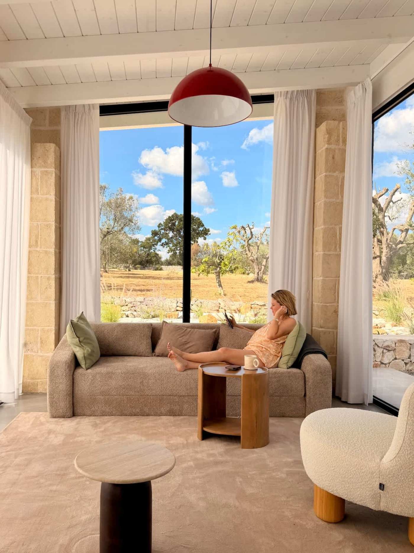Trullo Ostro: Living room sofa facing floor-to-ceiling garden windows