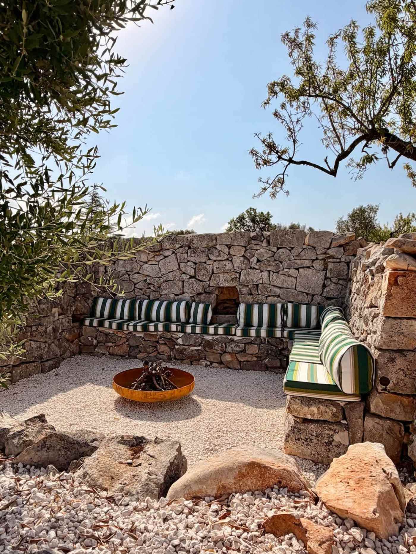 Trullo Ostro: Fire pit lounge with striped cushions and stone walls
