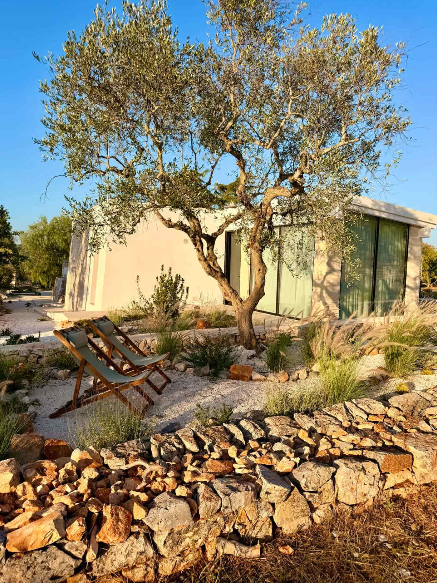 Trullo Ostro: Deck chairs in the garden beside the living wing