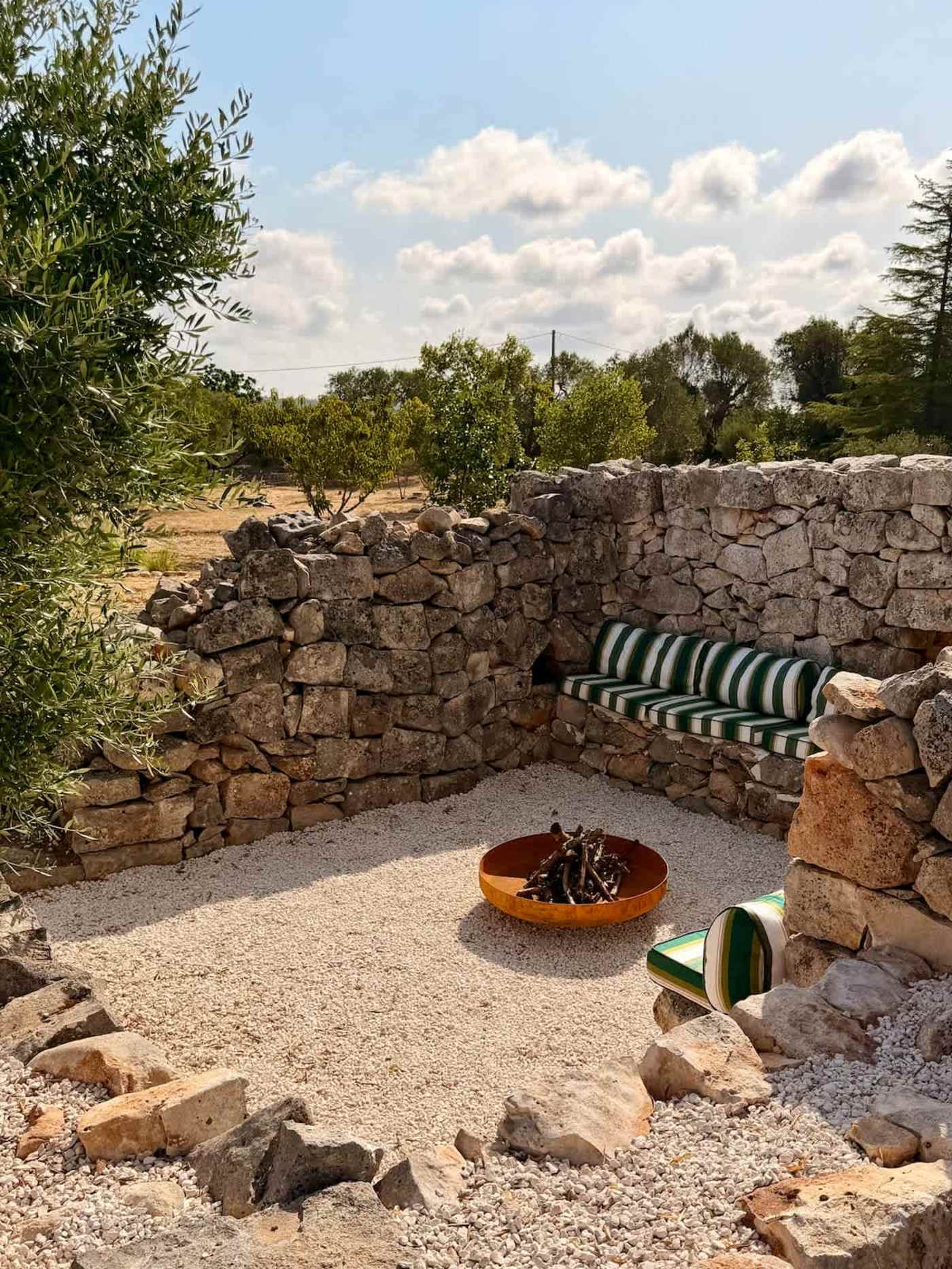Trullo Ostro: Fire pit lounge seen from above with olive grove beyond