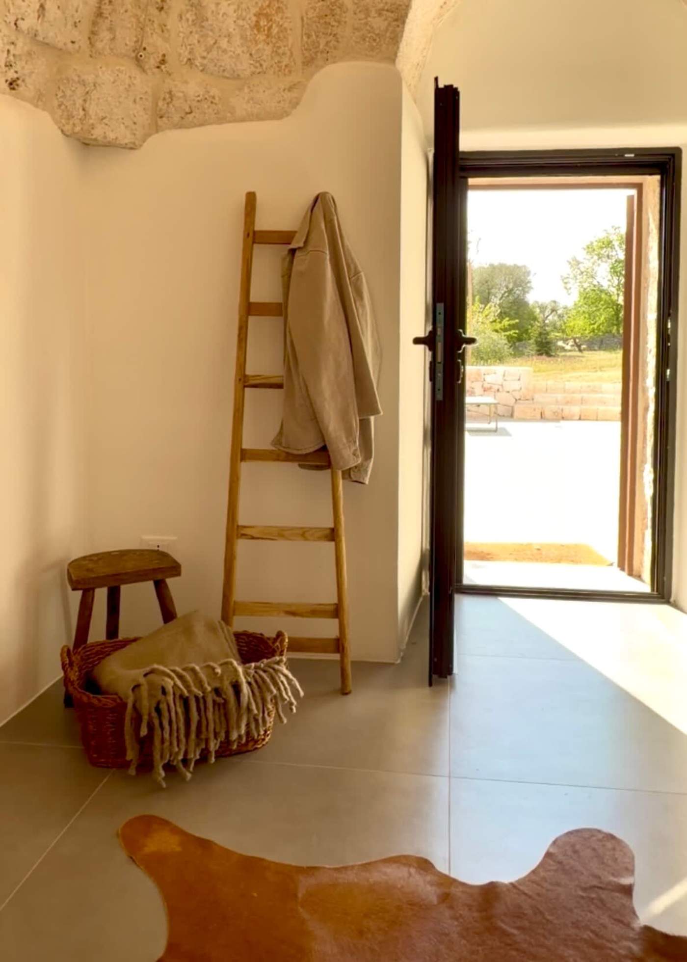 Trullo Ostro: Entry hall with ladder rack and door open to the terrace