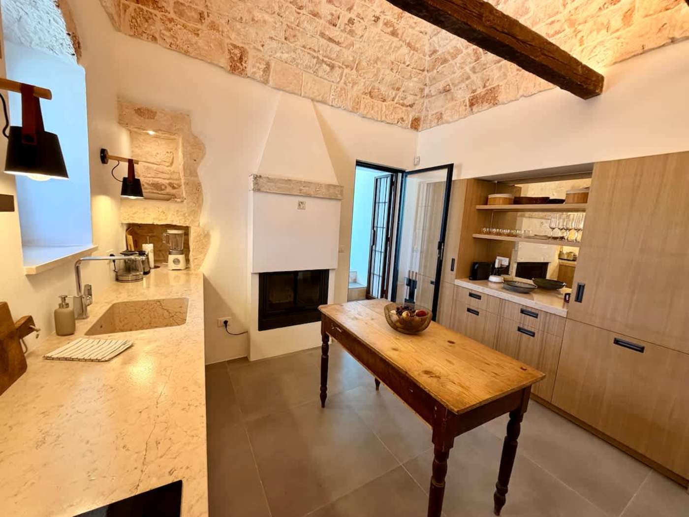 Trullo Ostro: Kitchen with fireplace, farmhouse table and stone ceiling