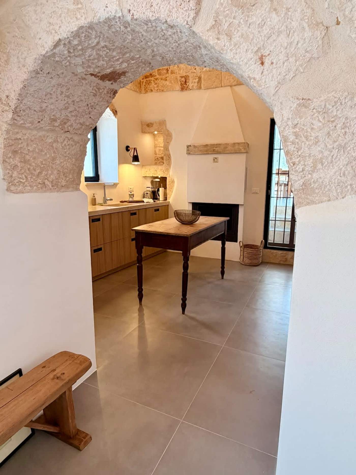 Trullo Ostro: View through a stone arch into the kitchen