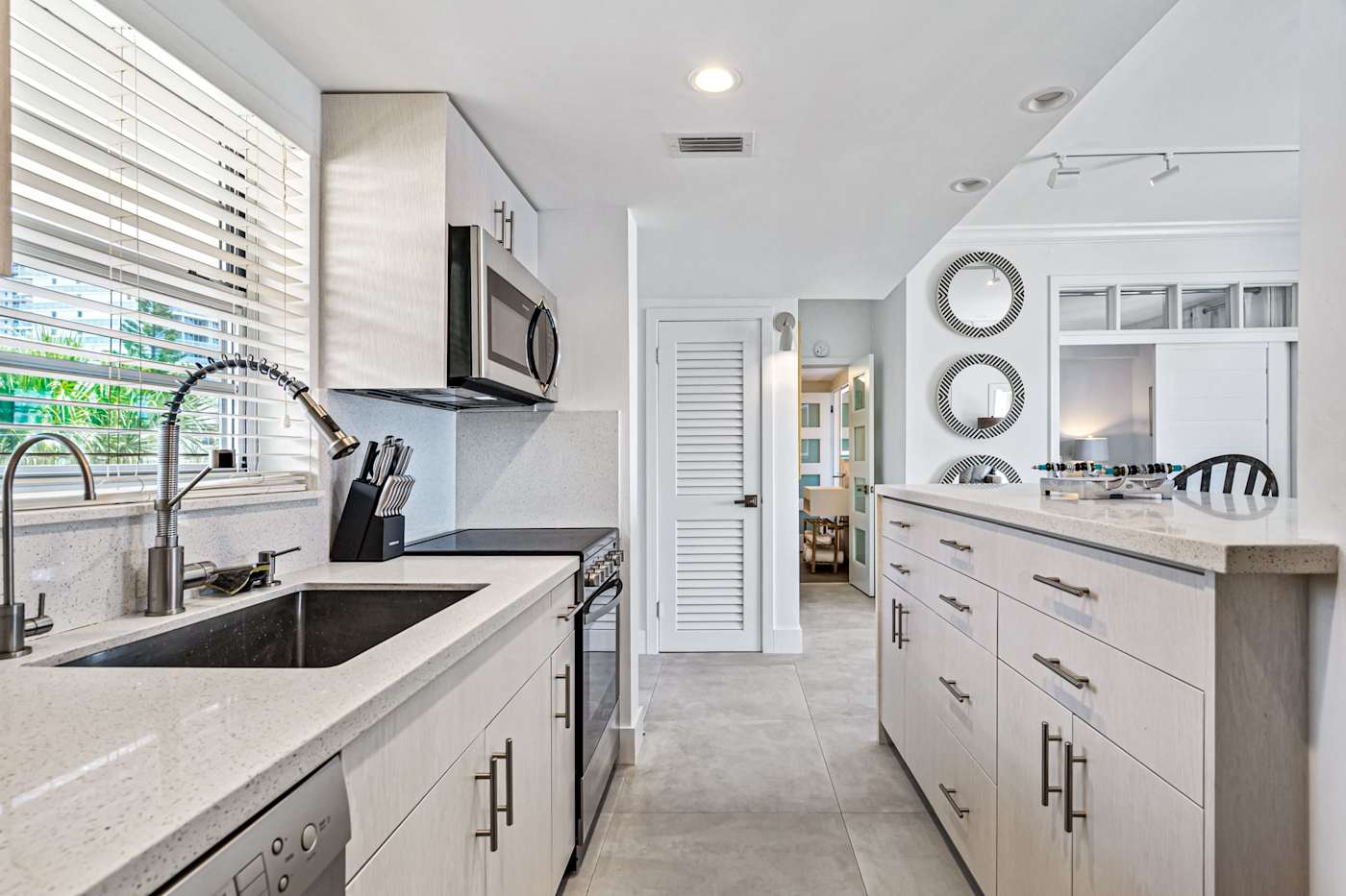Ocean Block: The galley kitchen has a large sink, a stove and a dishwasher