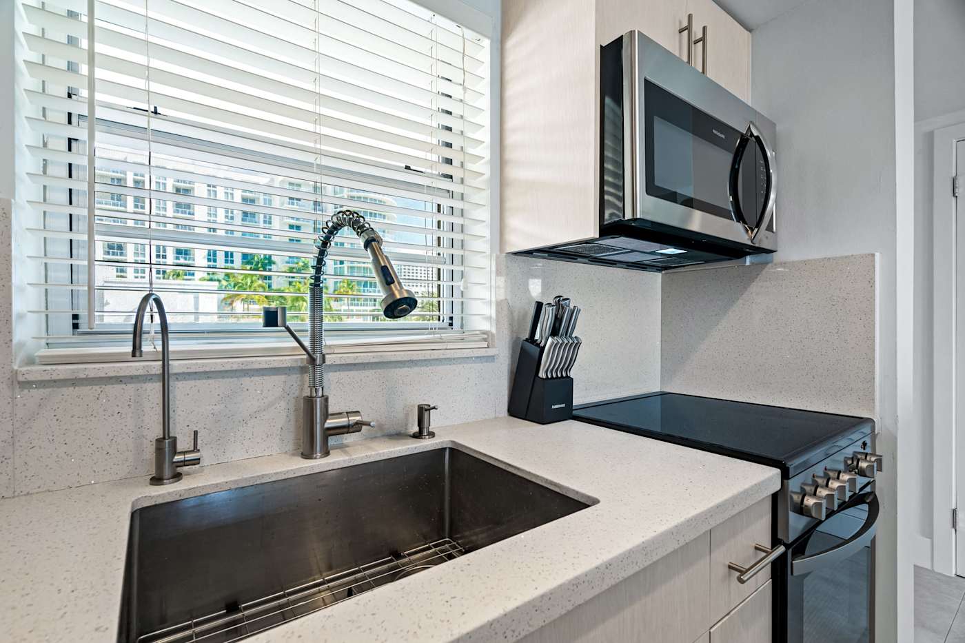 Ocean Block: The kitchen sink sits under a window, next to the stove and microwave