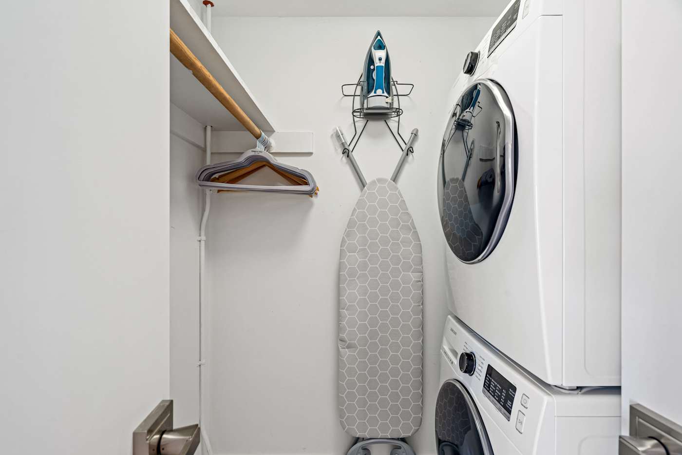 Ocean Block: A stacked washer and dryer sit beside a closet with an iron and ironing board