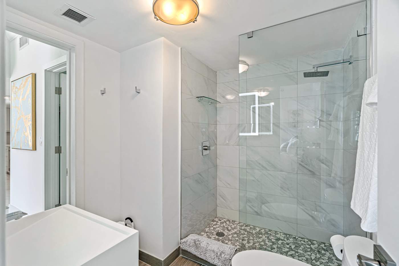 Ocean Block: The bathroom has a glass-enclosed walk-in shower with marble-look tile