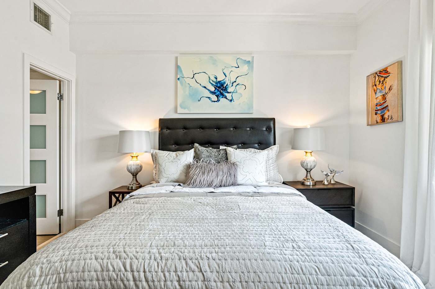 Ocean Block: This bedroom has a bed with a tufted headboard and two bedside lamps