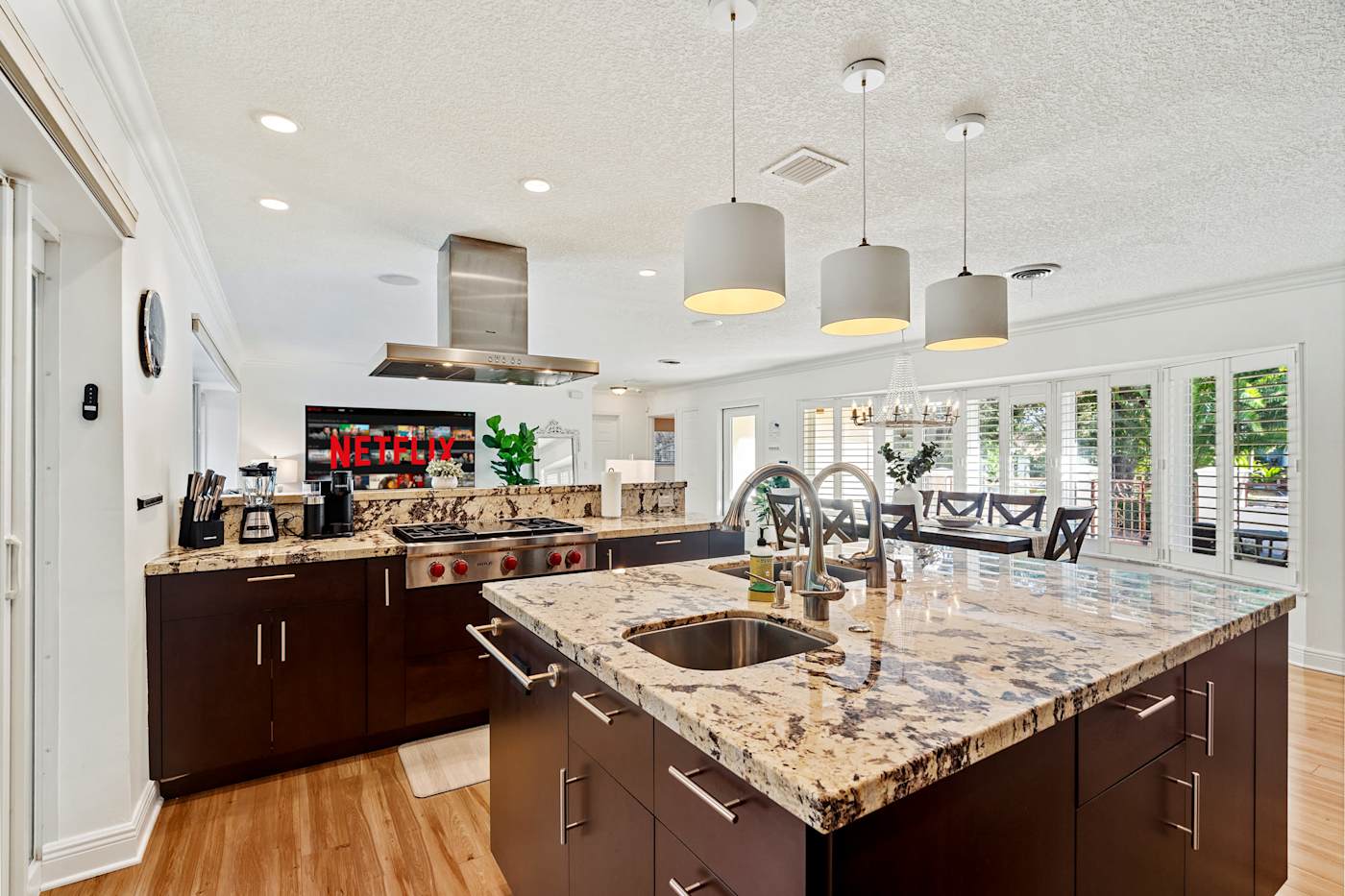 Cypress Cove: The kitchen has a granite island with a sink and pendant lights above