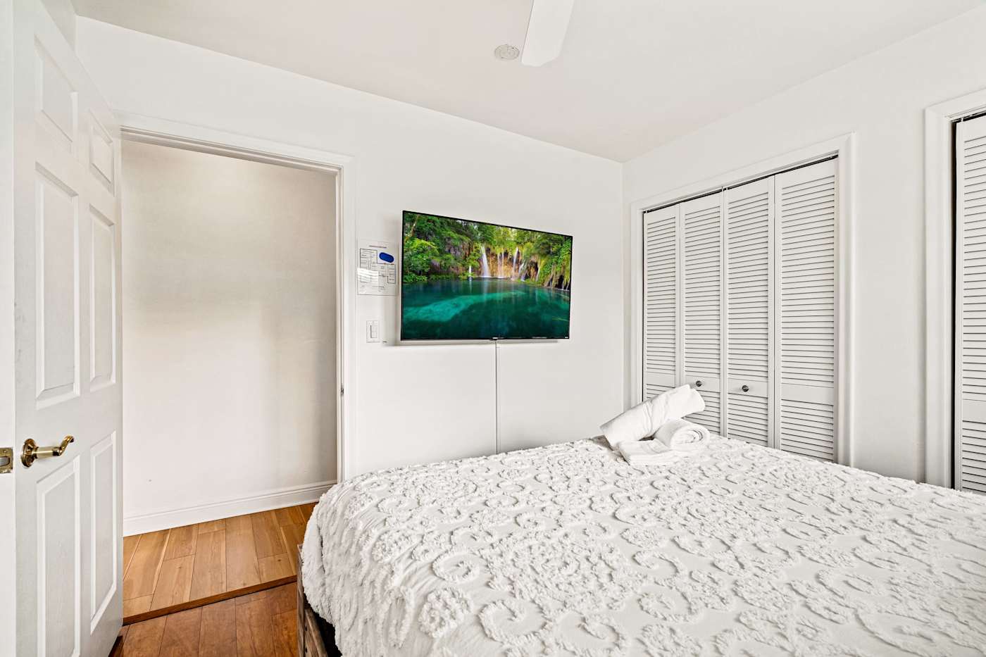 Cypress Cove: This bedroom has a bed, a wall-mounted TV and a closet