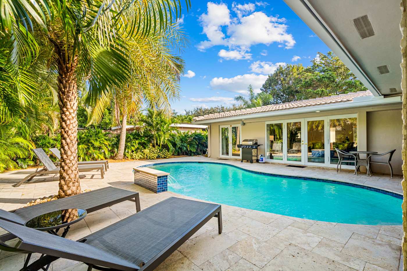 Cypress Cove: Sun loungers line the deck around the pool, with a grill by the house