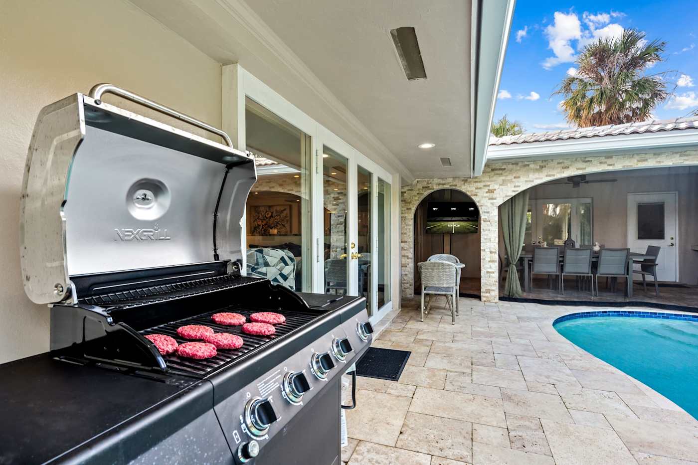 Cypress Cove: A gas grill sits on the pool deck next to the screened dining lounge