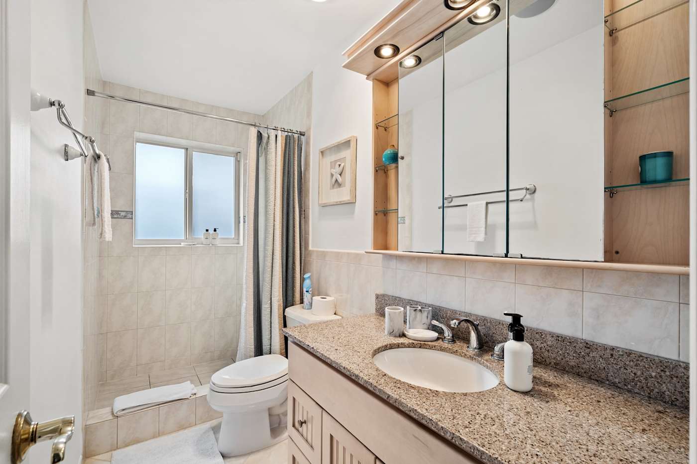 Cypress Cove: The bathroom has a shower with a curtain, a vanity and a mirrored cabinet