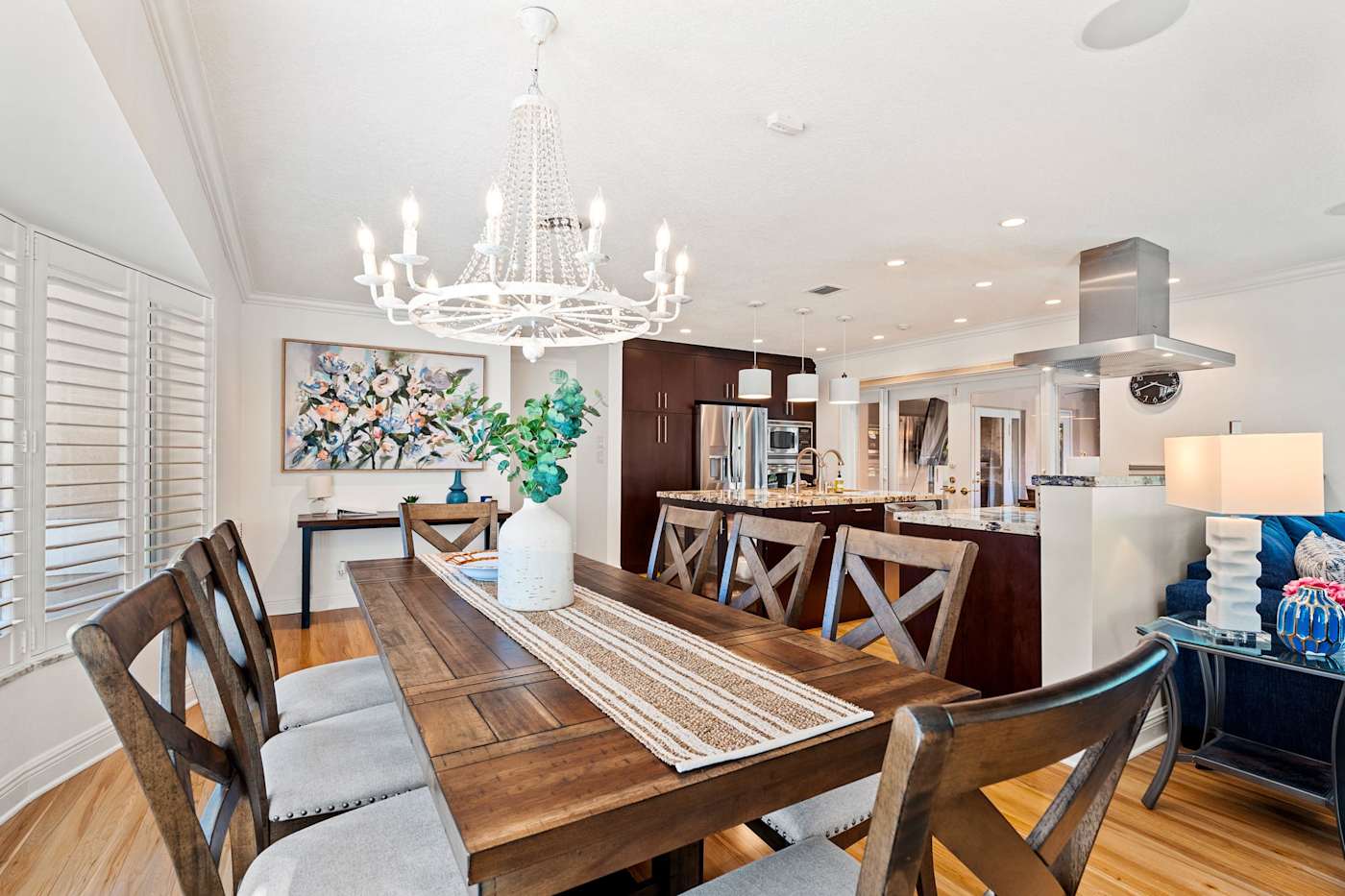 Cypress Cove: The dining table seats eight under a chandelier, next to the kitchen