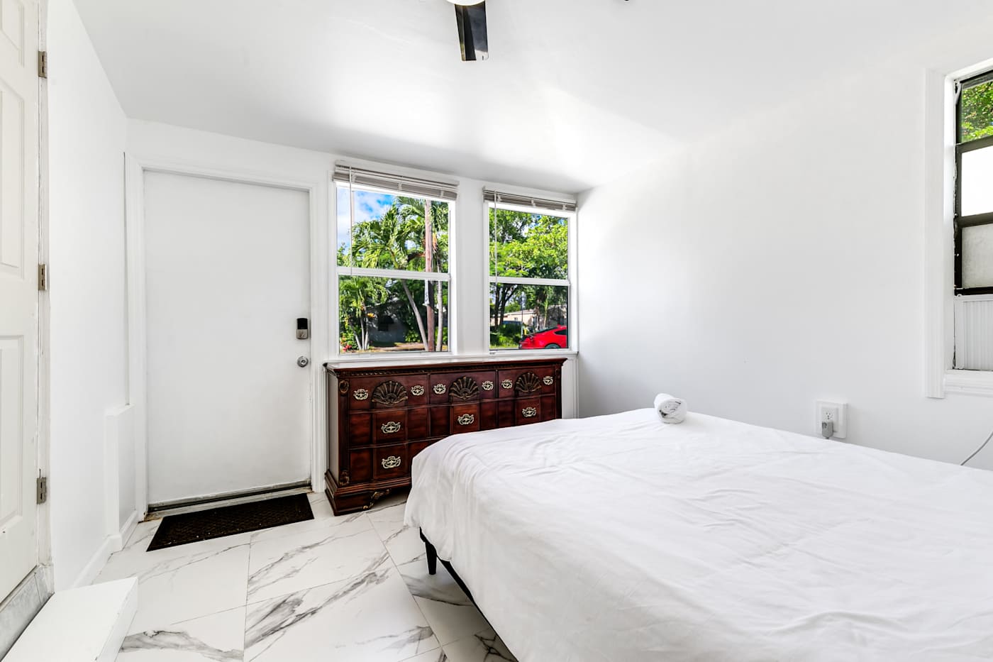 Pompano Bungalow: This bedroom has a bed, a wood dresser and its own door to the outside