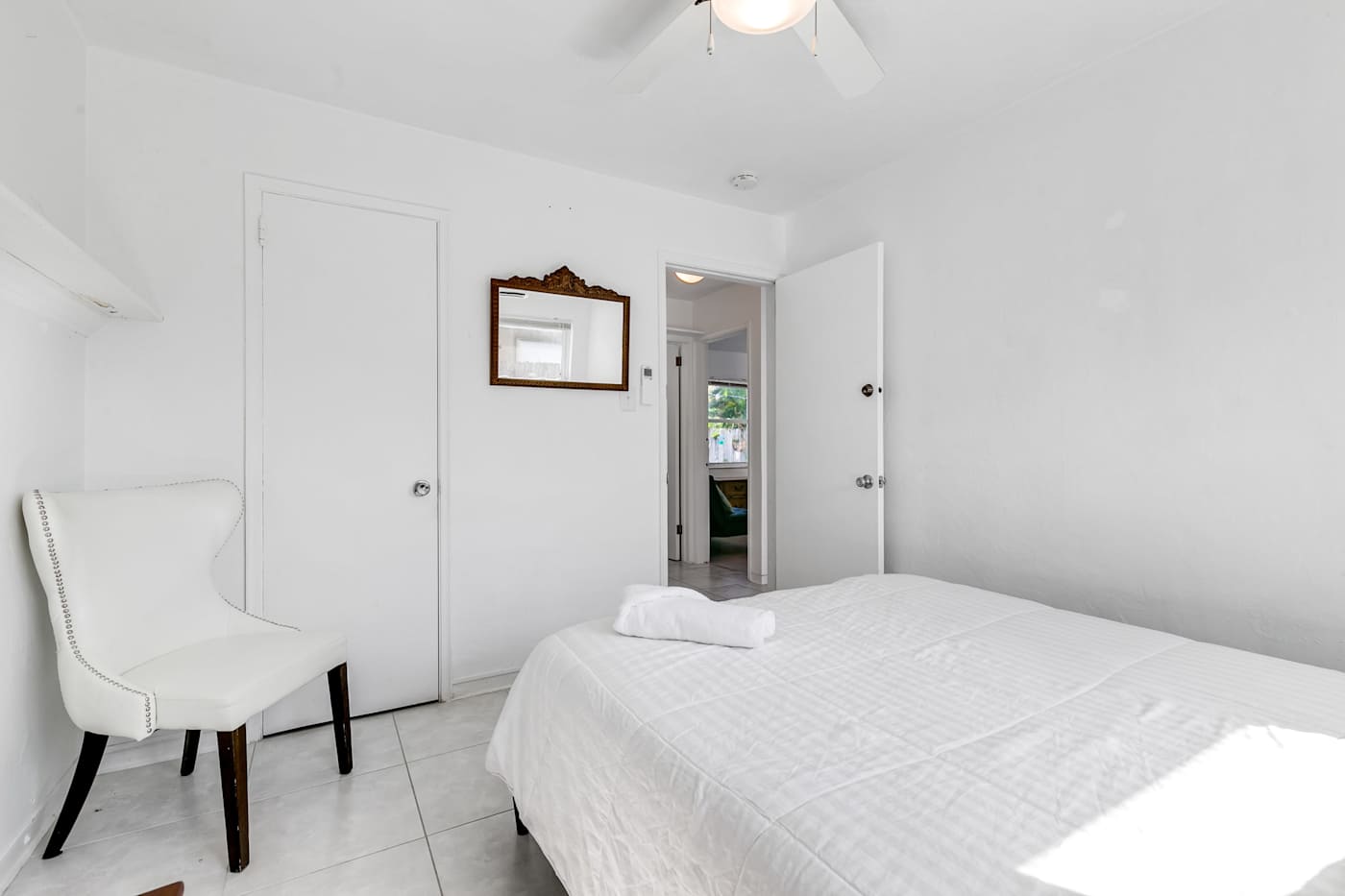 Pompano Bungalow: This bedroom has a bed, an accent chair and a closet