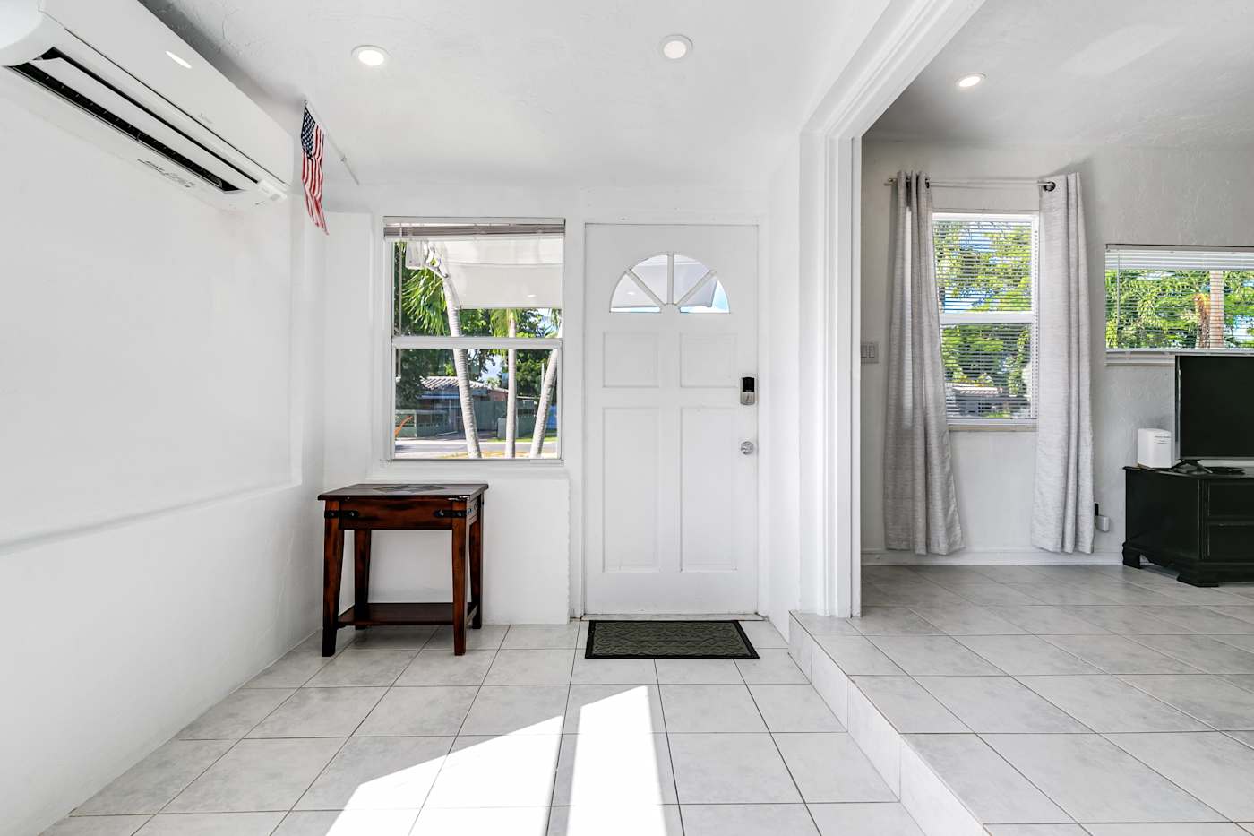 Pompano Bungalow: The front entry opens into a bright tiled hallway by the living room