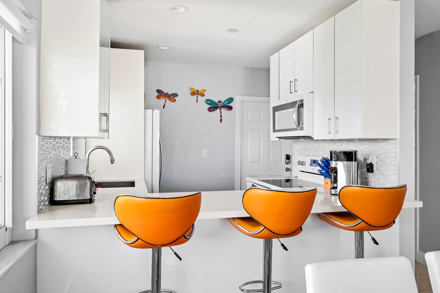 Pompano Condo: The kitchen has a breakfast bar with three orange stools