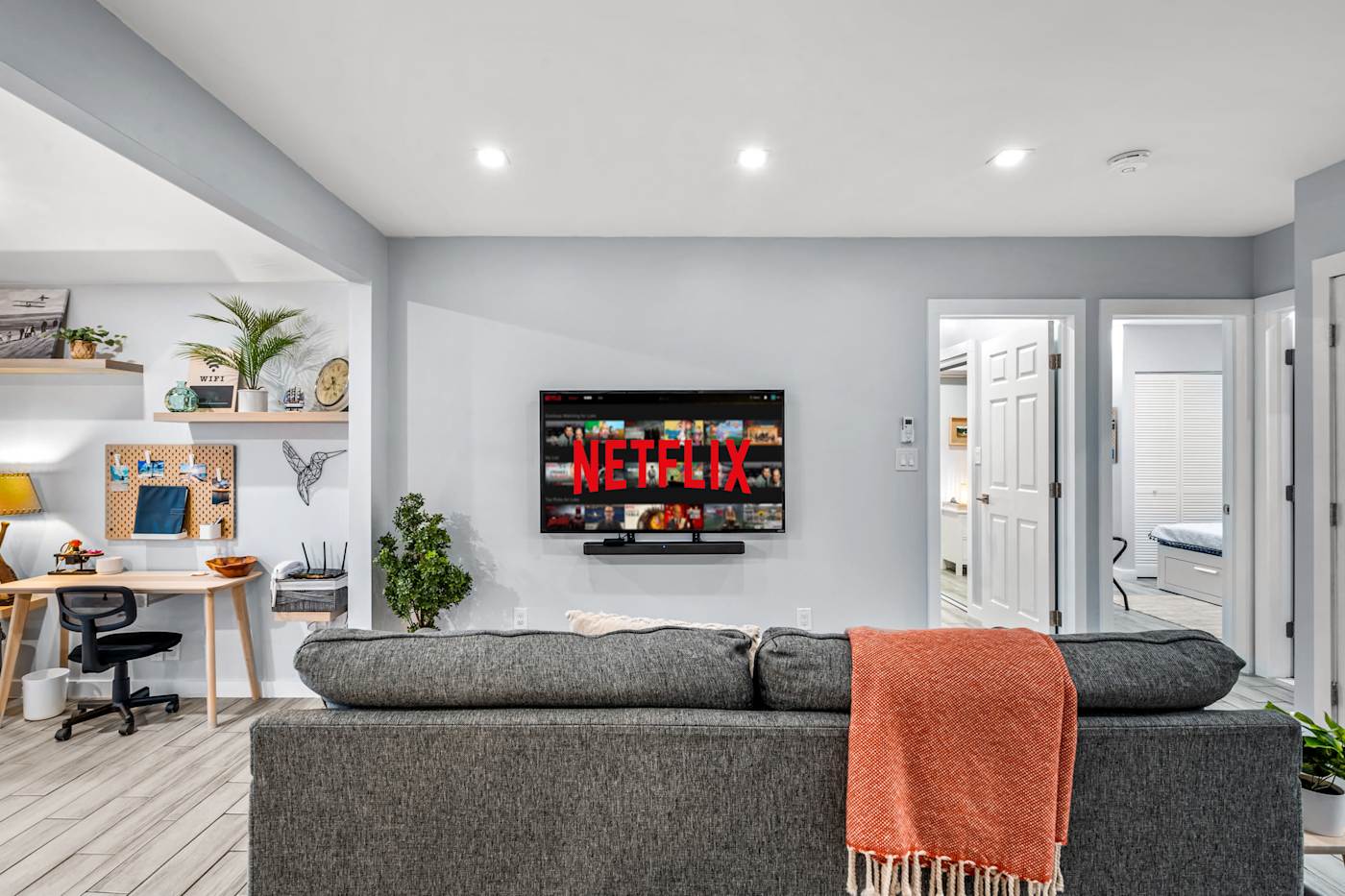 EV Retreat: The living room has a sofa, a Smart TV and a desk nook in the corner