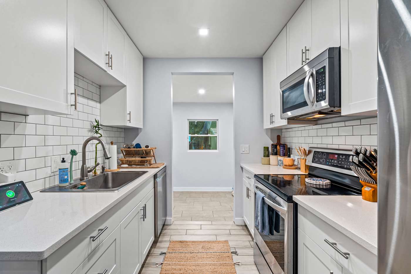 EV Retreat: The galley kitchen has white cabinets, a stove and a microwave