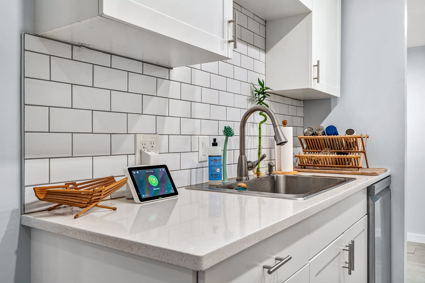 EV Retreat: The kitchen sink sits beside a dish rack and a smart display