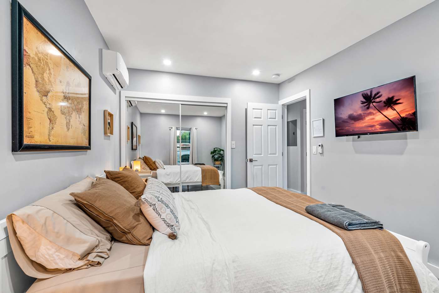 EV Retreat: This bedroom has a bed, a wall-mounted TV and a mirrored closet