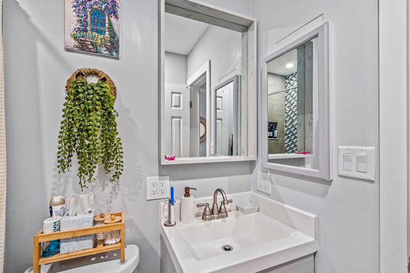 EV Retreat: The bathroom vanity has a sink and a mirror, with toiletries on a small shelf