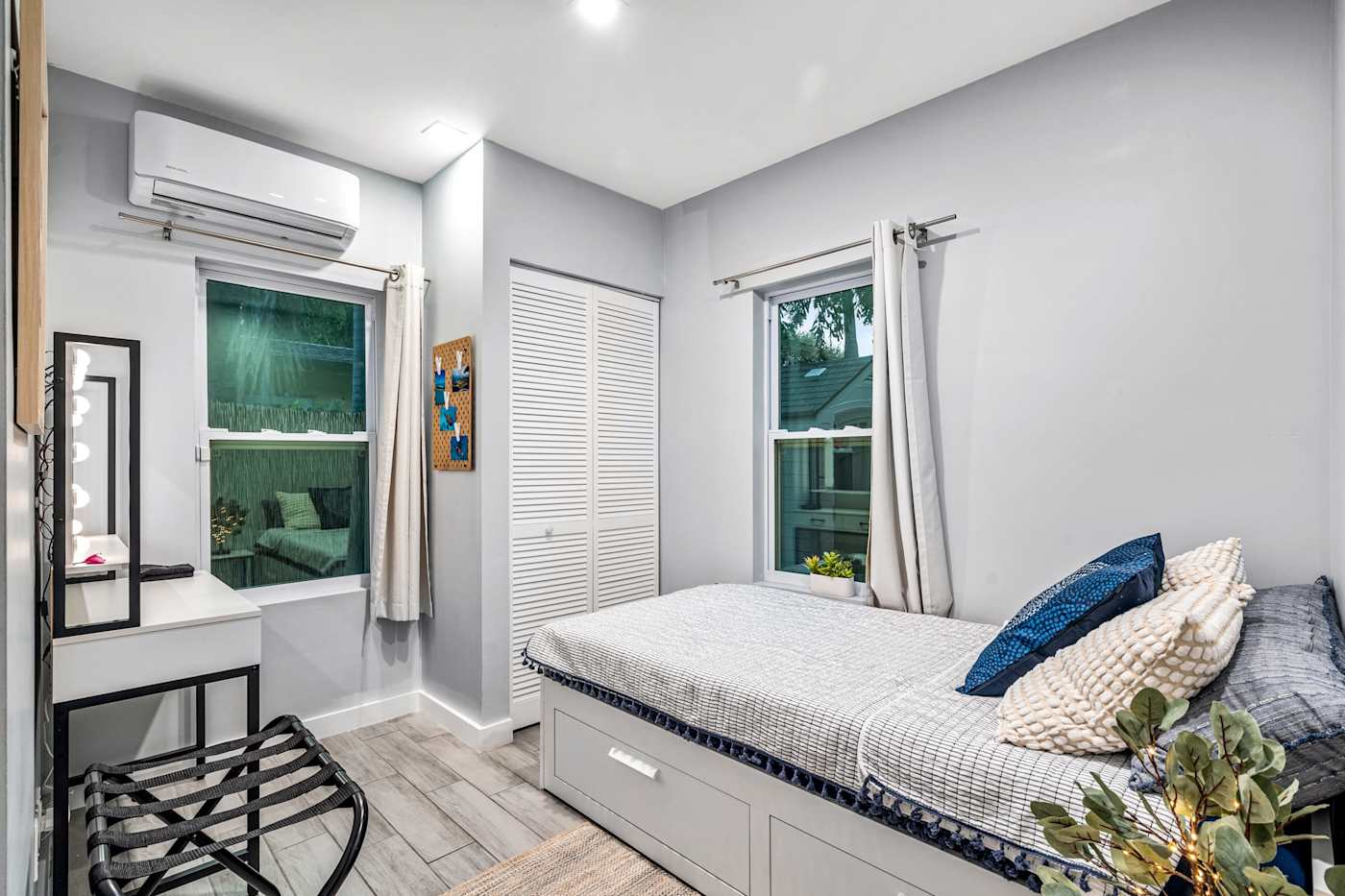 EV Retreat: This bedroom has a bed with storage drawers and a vanity with a mirror