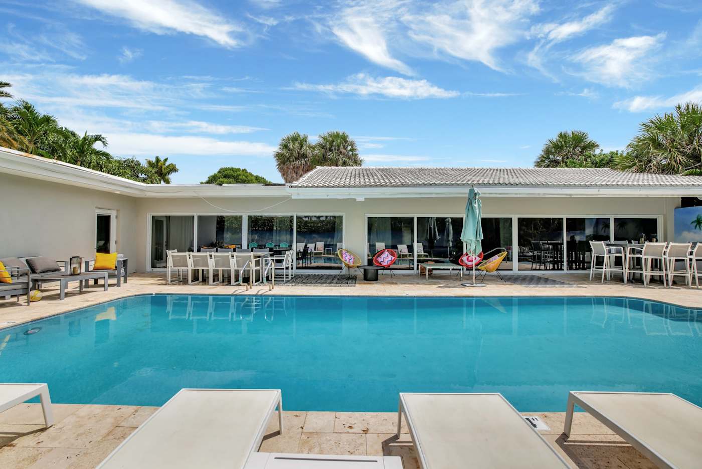 6 Bed Beach House: The house seen across the pool, with loungers on the deck