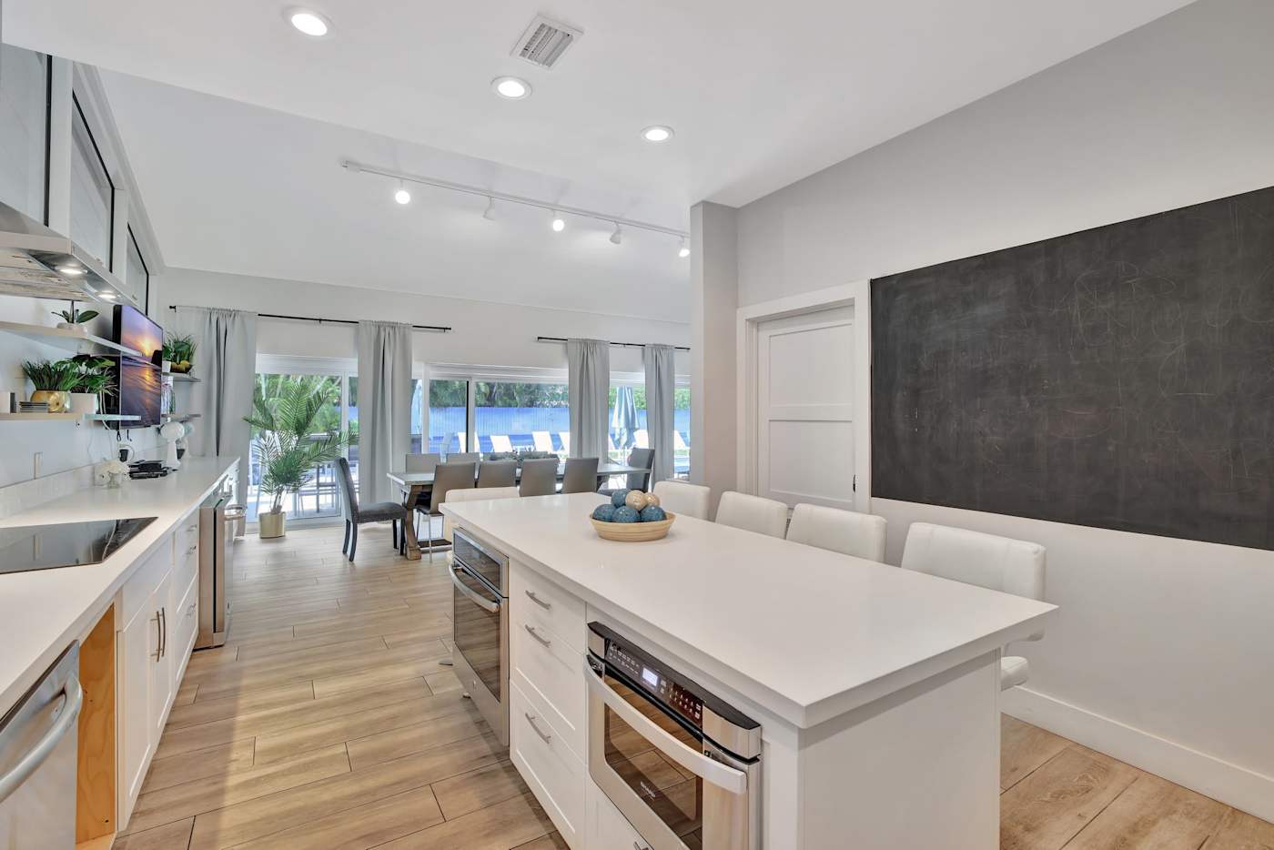 6 Bed Beach House: Kitchen and breakfast bar, with the pool beyond