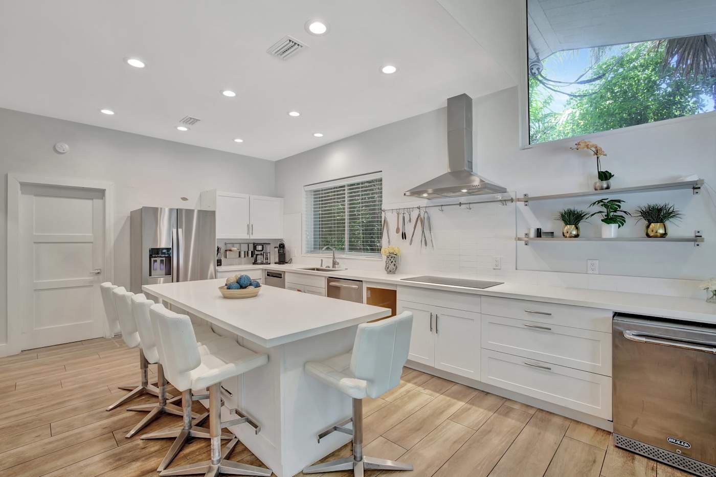 6 Bed Beach House: Kitchen island with bar stools and a window over the sink