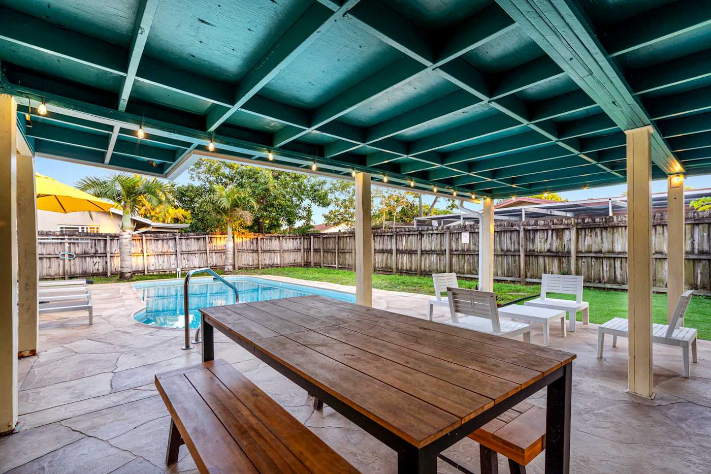 The Game House: Picnic table under the covered patio, with the pool beyond