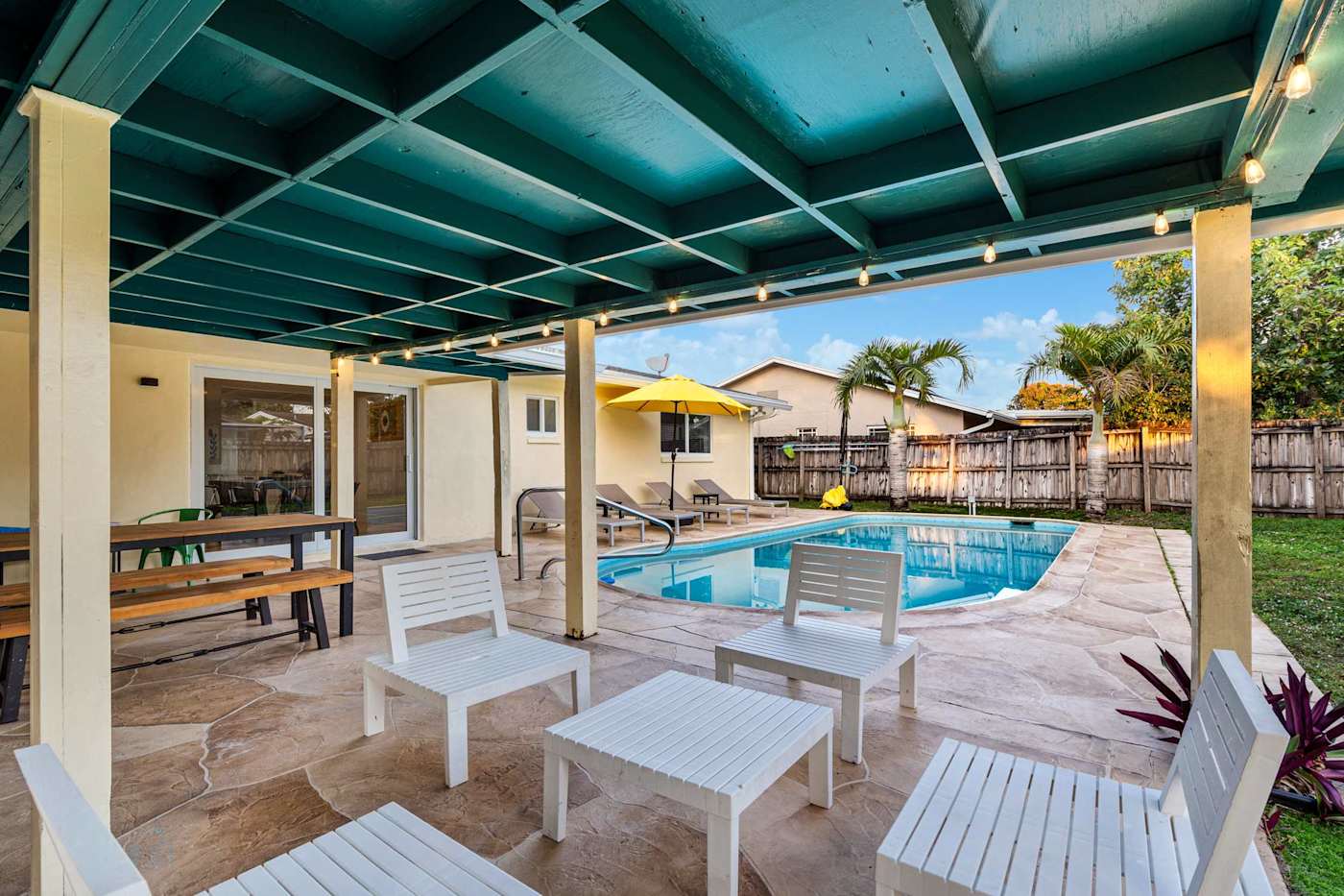 The Game House: Covered patio with seating and dining, beside the pool