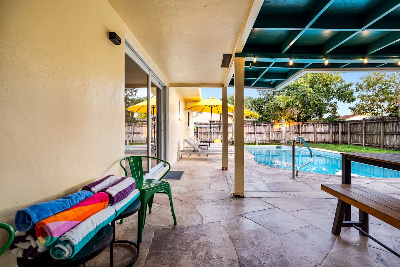 The Game House: Covered patio with pool towels, looking out to the pool