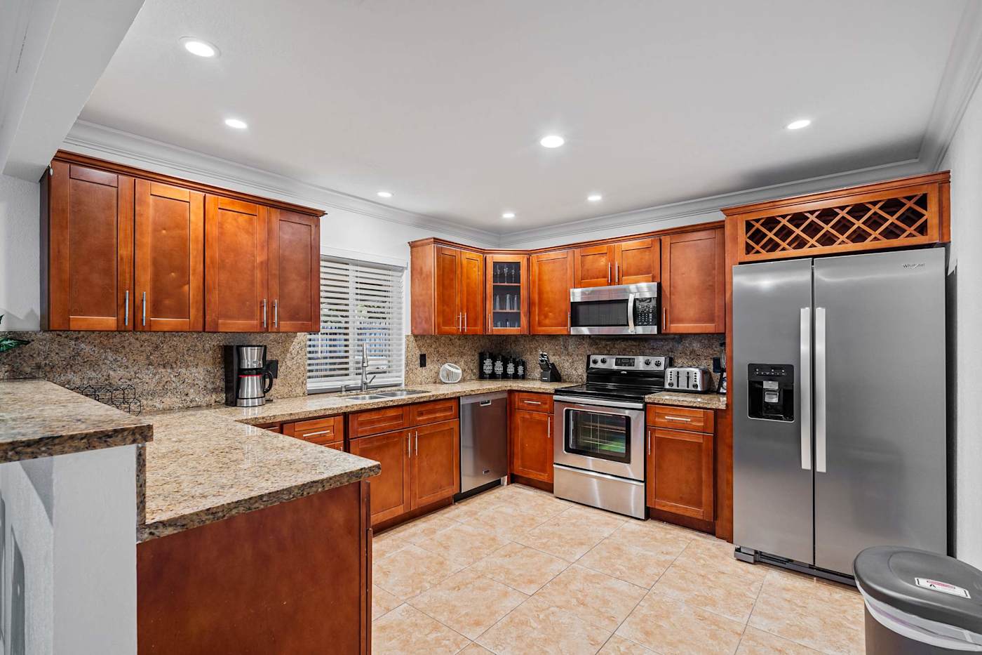 The Game House: Kitchen with wood cabinets, electric range and large fridge