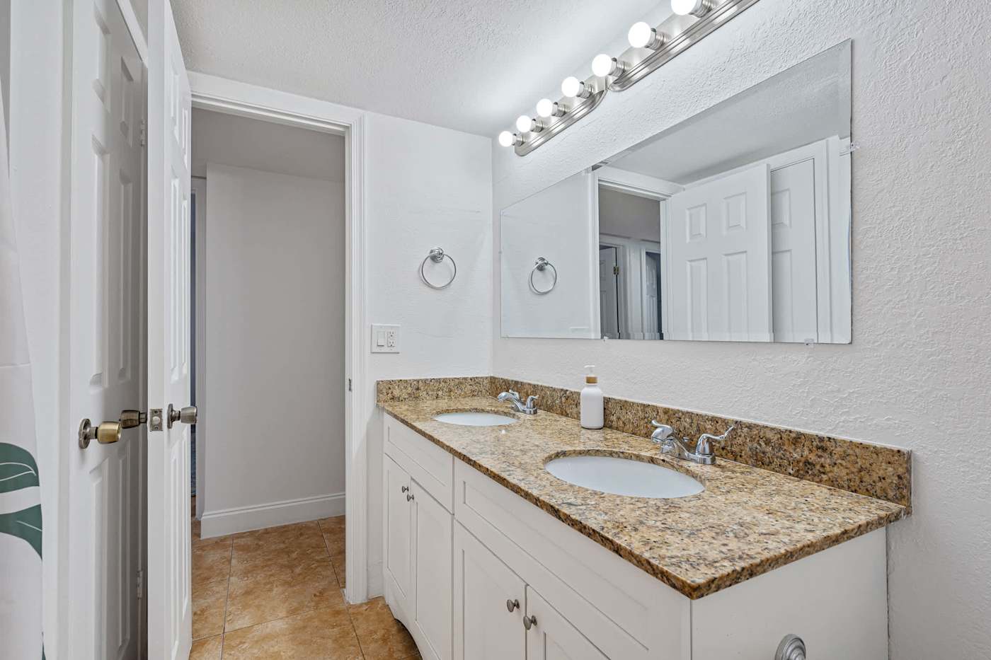 The Game House: Bathroom with double vanity and a mirrored wall