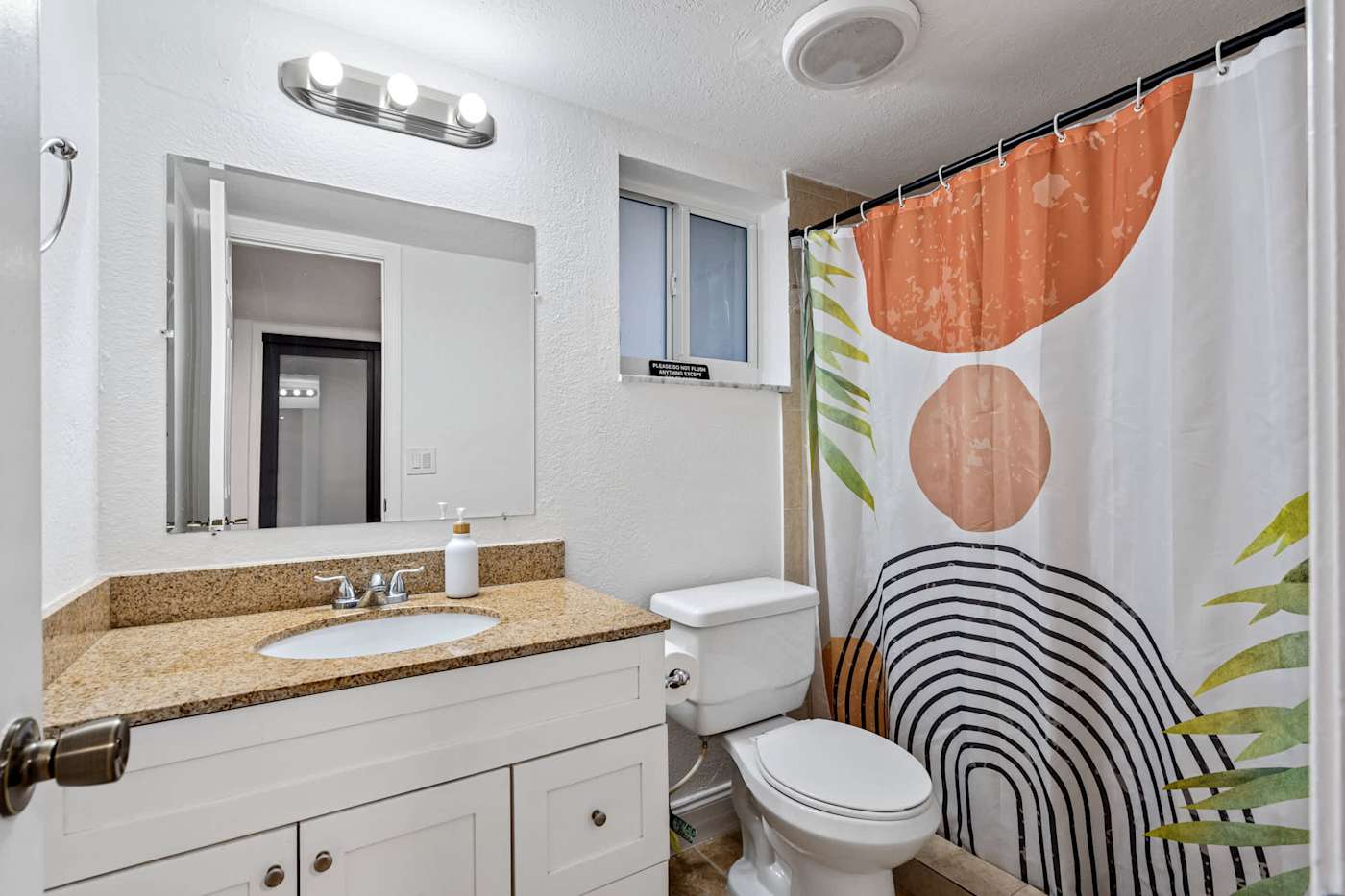 The Game House: Bathroom with vanity, mirror and shower over bath