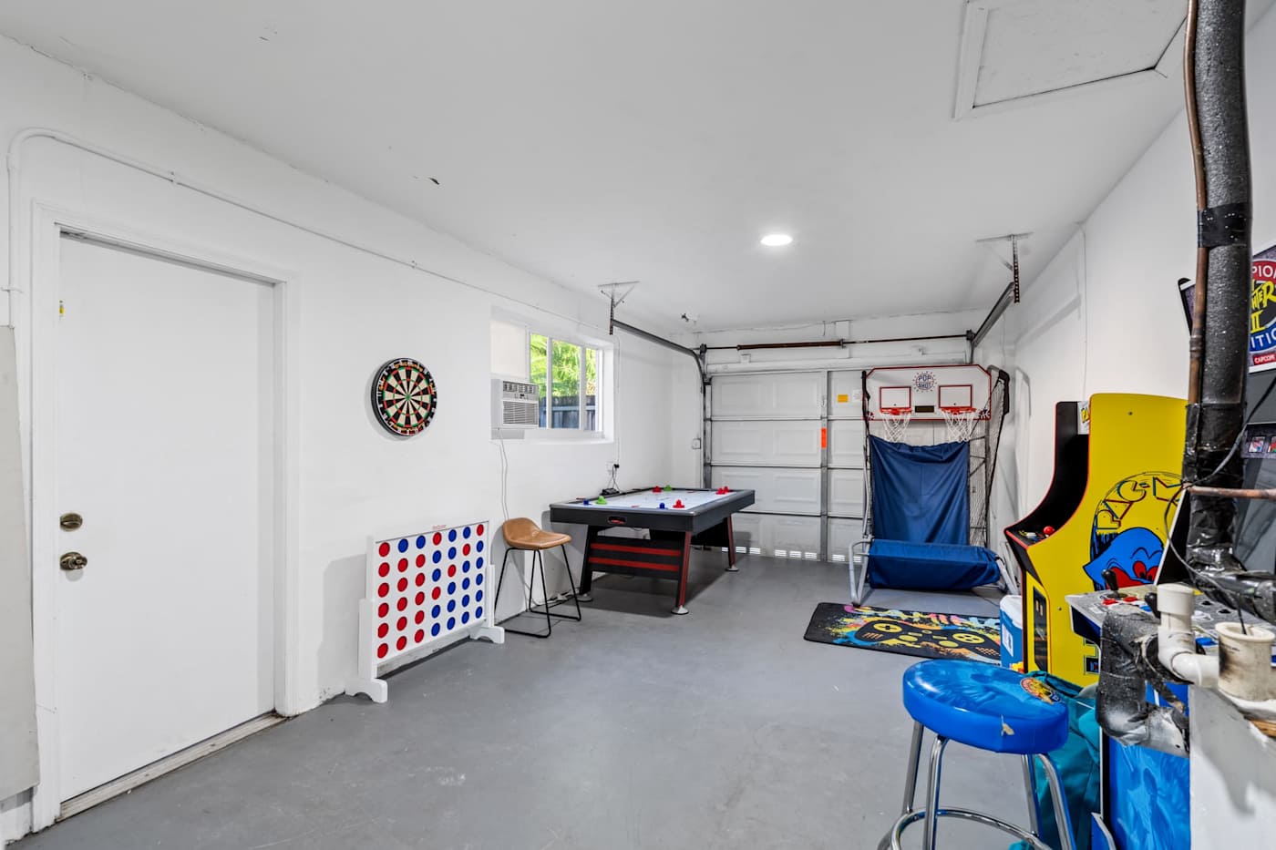 The Game House: Games room in the garage with darts, arcade machines and air hockey