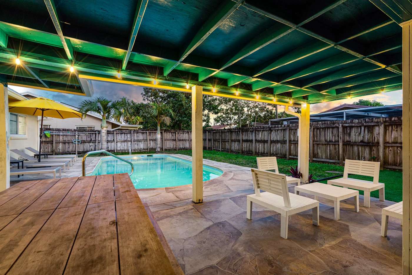 The Game House: Covered patio and pool lit at dusk