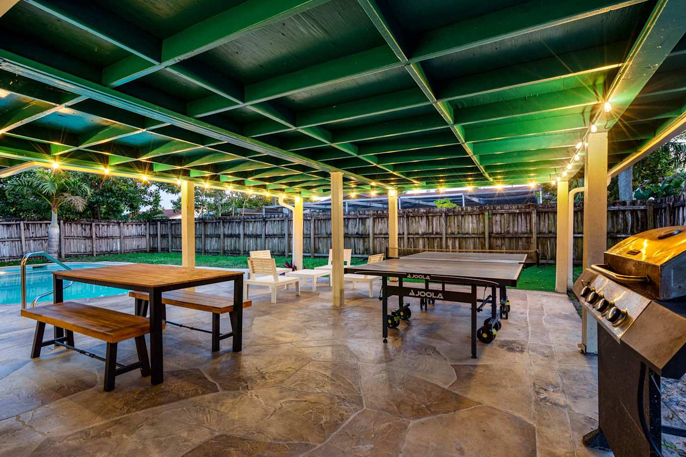 The Game House: Picnic table and ping pong on the covered patio, beside the grill
